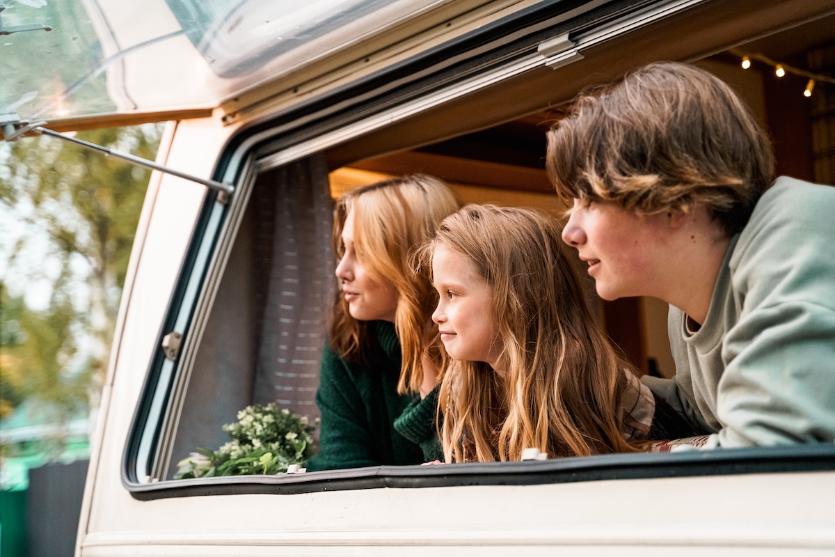 family looking out from their car arriving on their family vacation